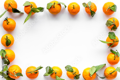 Tangerines with leaves frame on white background top-down copy space