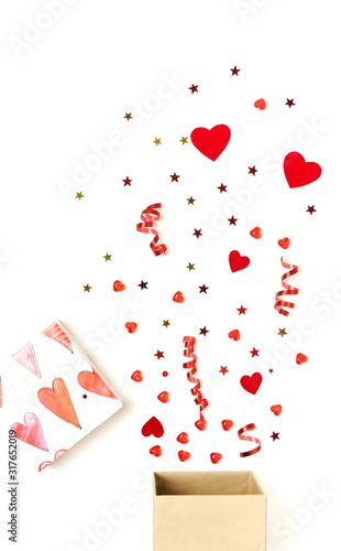 Valentine's day background.  gift box with various party confetti, red hearts...