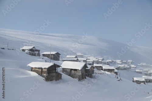 mountain landscape slopes covered with snow can be seen a tree fence and a house.savsat/artvin