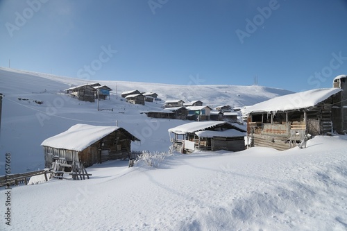 mountain landscape slopes covered with snow can be seen a tree fence and a house.savsat/artvin © murat