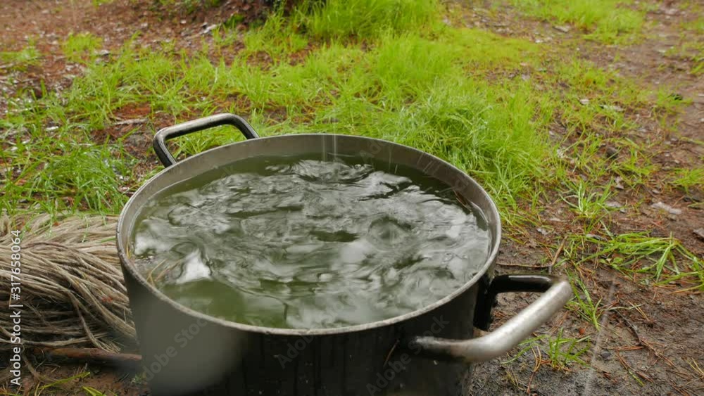 Adventures of hunters in Karelia. Rainwater is collected in a huge pot set near a hunting hut. Adventures of hunters in Karelia. Rainwater is collected in a huge pot set near a hunting hut.