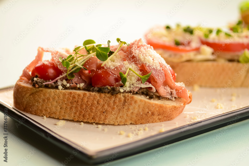 Traditional Italian bruschetta with parmesan cheese, tomato, prosciutto meat, mushrooms, seasoned with herbs
