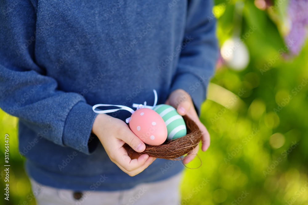 Pretty little boy wearing bunny ears hunting for easter eggs in spring park on Easter day. Pretty little boy wearing bunny ears hunting for easter eggs in spring park on Easter day.