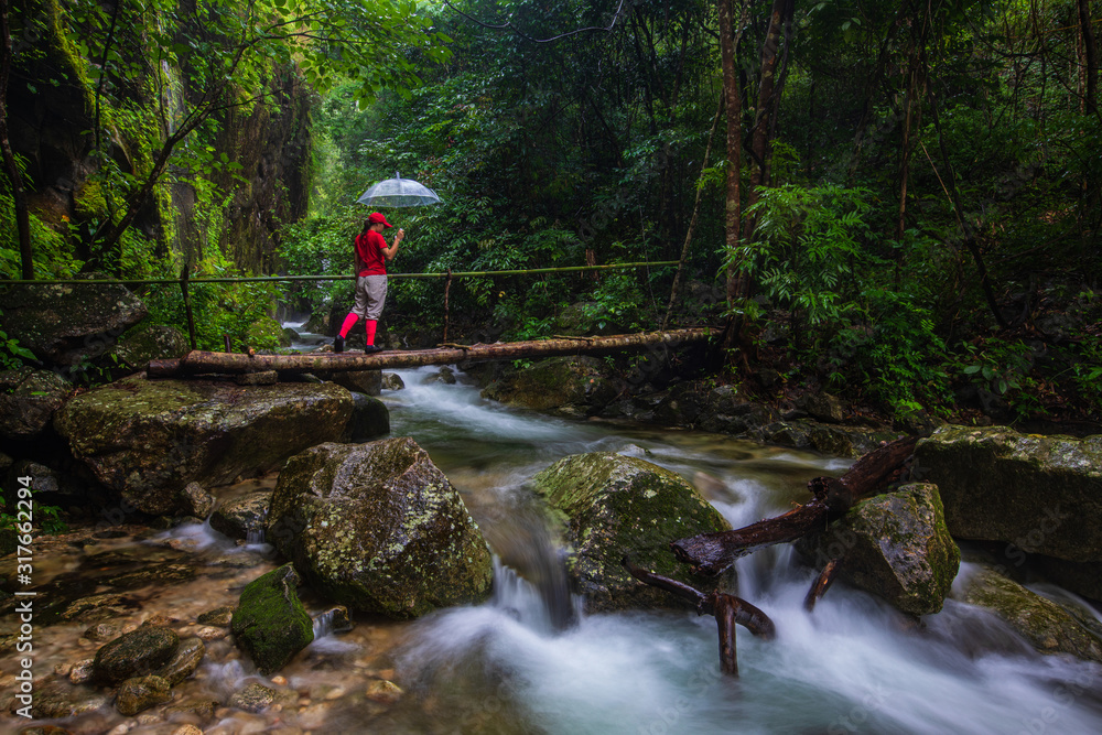 The girl in  touring on Pi-tu-gro waterfall, Beautiful waterfall in Tak  province, ThaiLand.