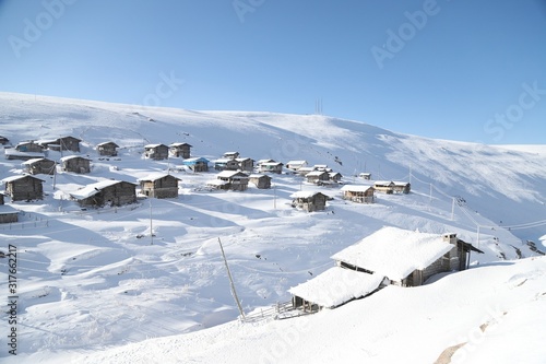 mountain landscape slopes covered with snow can be seen a tree fence and a house.savsat/artvin