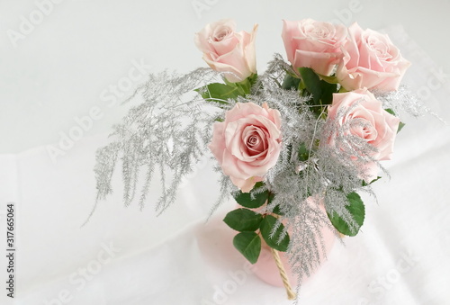 Beautiful pink roses in a pink vase on white table top view. Home interiour. ...