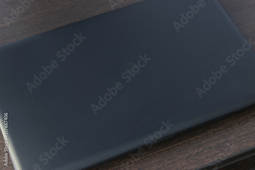a closed black laptop is lying on the table