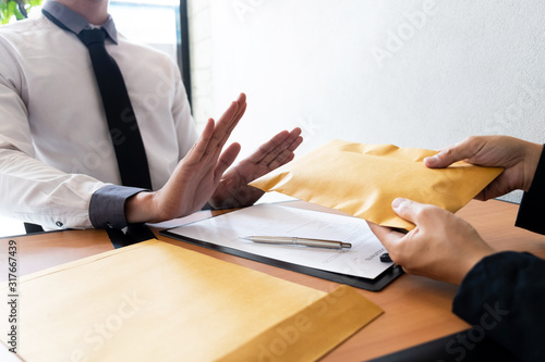 Billede på lærred The businessmen refusing accept bribes in a brown envelope at the office