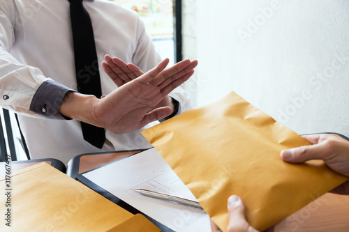 Photos The businessmen refusing accept bribes in a brown envelope at the office