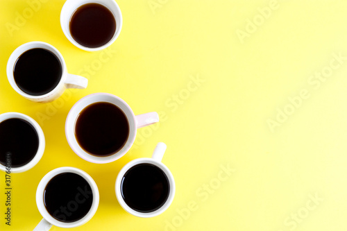 A lot of coffee cups on a yellow background. Color of the year 2021.