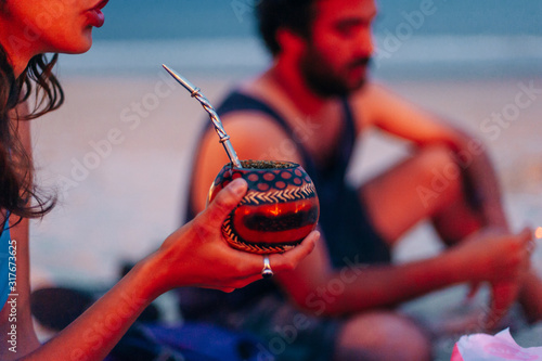 Young woman drinking traditional Argentinian yerba mate tea from a calabash photo