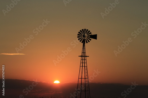 windmill at sunset with a colorful sky and cloud's. © Stockphotoman