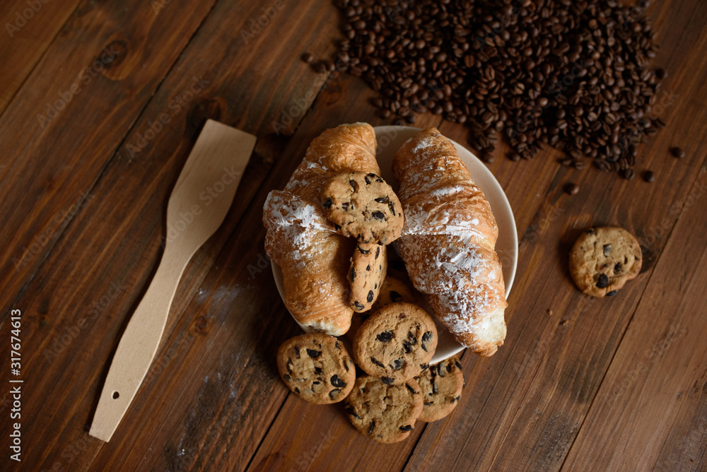 Breakfast capuccino, croissant and delicious cookies on a wooden table. Breakfast capuccino, croissant and delicious cookies on a wooden table.
