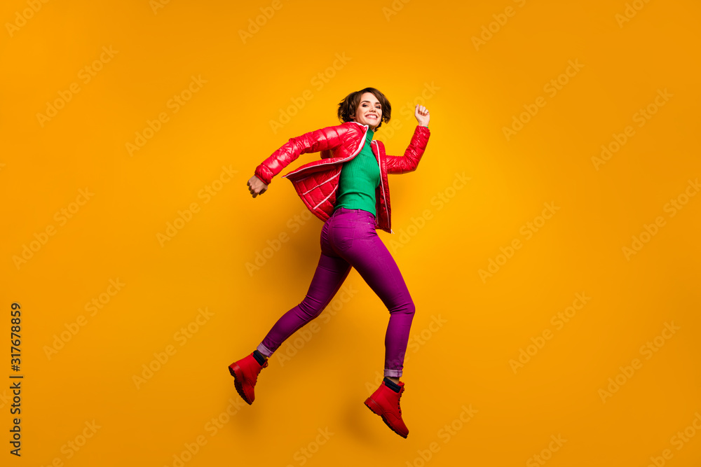 Full size profile photo of funny lady jumping high rushing shopping discount prices wear casual red overcoat trousers turtleneck boots isolated yellow color background