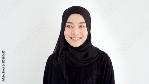 Close Up Portrait of a Young Asian Muslim Woman dressing in the traditional Hijab looking at camera smiling confident on a white background