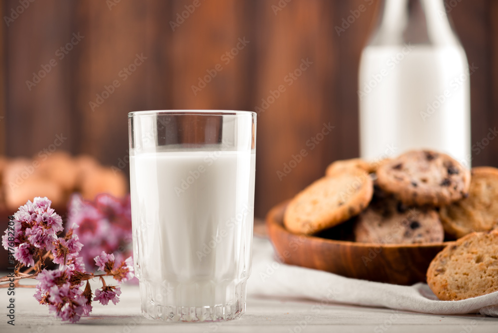 Chocolate chip cookies with milk on burlap and rustic wooden table Chocolate chip cookies with milk on burlap and rustic wooden table
