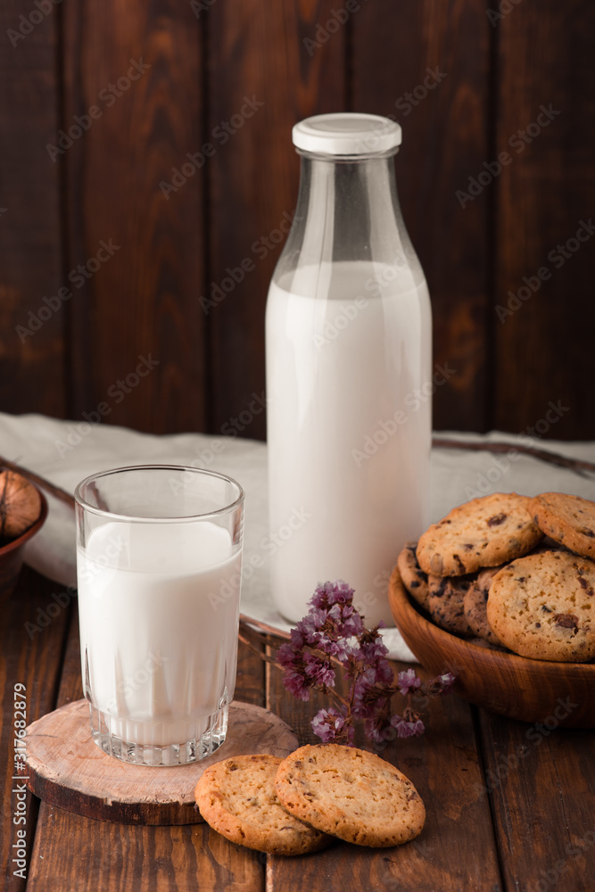Chocolate chip cookies with milk on burlap and rustic wooden table Chocolate chip cookies with milk on burlap and rustic wooden table