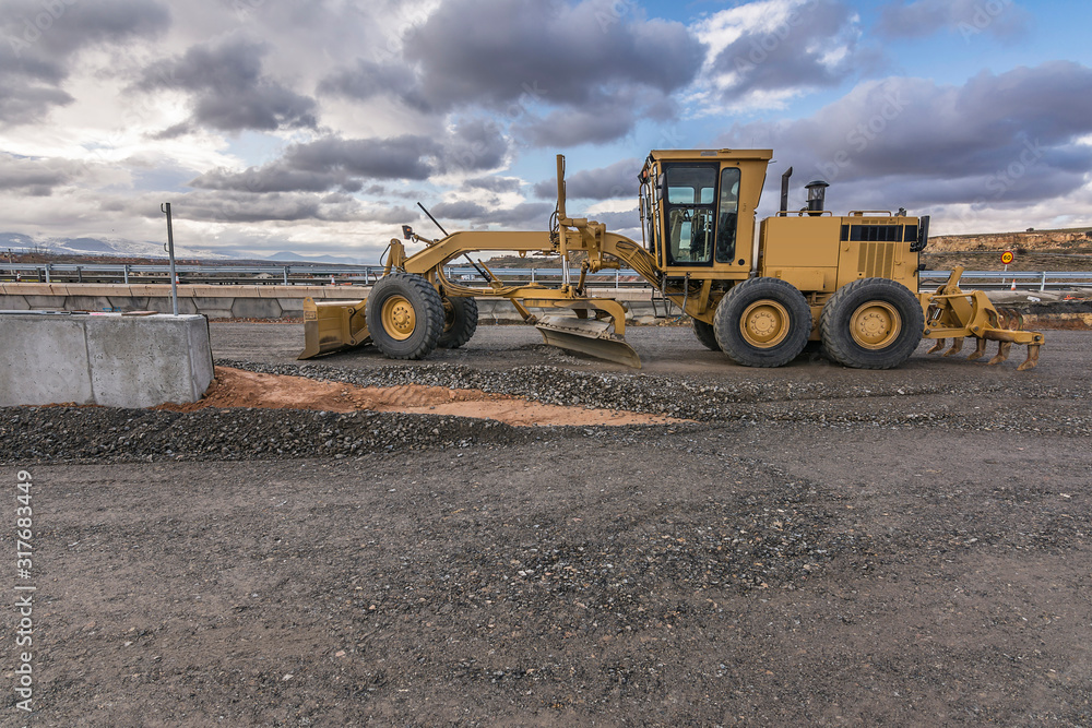 Obraz premium Excavator machine leveling the ground with a large shovel