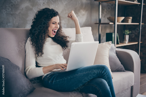 Portrait of her she nice-looking attractive lovely cheerful cheery wavy-haired girl using laptop celebrating accomplishment in modern loft industrial style interior room indoors