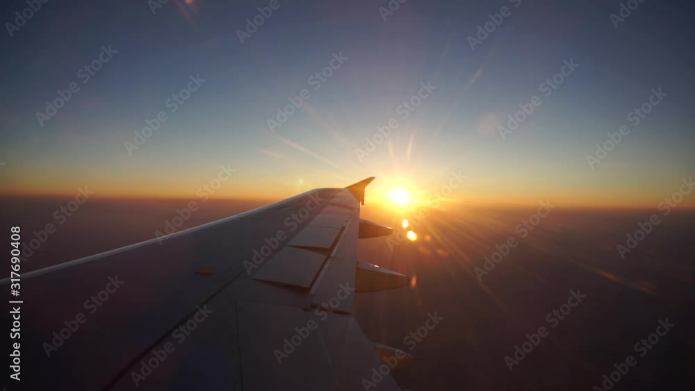 Traveling by plane with the bright sun setting in the horizon - Mid shot Traveling by plane with the bright sun setting in the horizon - Mid shot