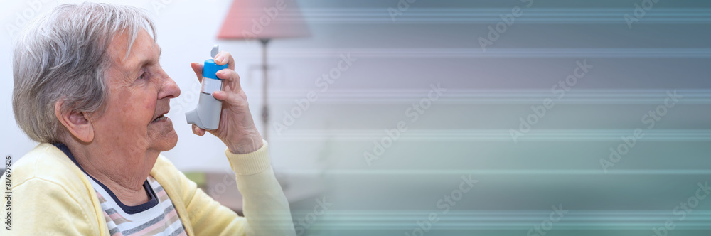 Old woman using an asthma inhaler; panoramic banner Old woman using an asthma inhaler; panoramic banner