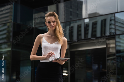 Portrait of business woman holding a tablet computer. Business woman on a meeting and waiting business partner and holding a tablet in hands.