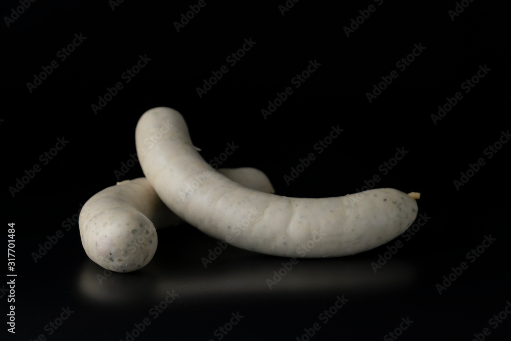 Two long white raw bratwurst sausage isolated on black background Two long white raw bratwurst sausage isolated on black background