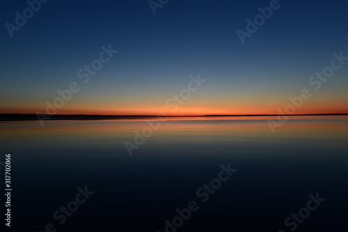 Glowing twilight red colors on the horizon on a blue sky background at sunset