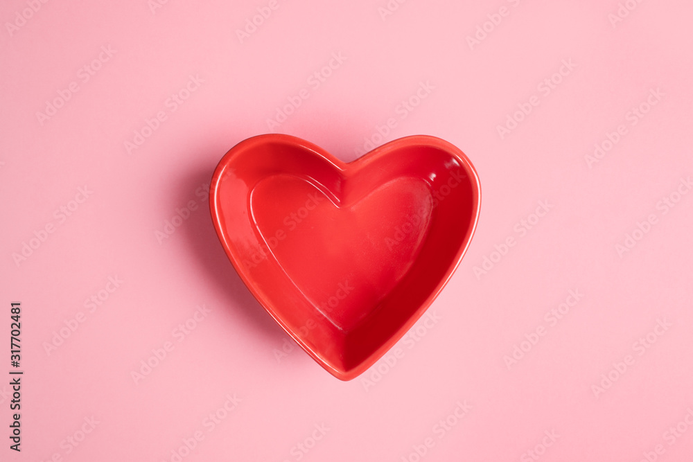 Close-up red heart shaped plate on pink background. Valentines day empty mockup.