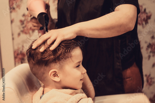 Small boy getting his hair dried after a haircut.