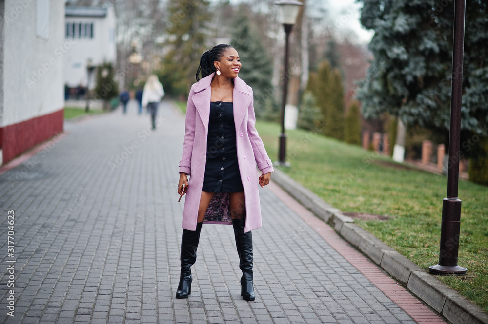 Young stylish beautiful african american woman in street, wearing fashion outfit coat.