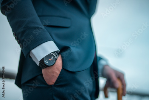 A close-up watch of business man in suit his hand in his pocket