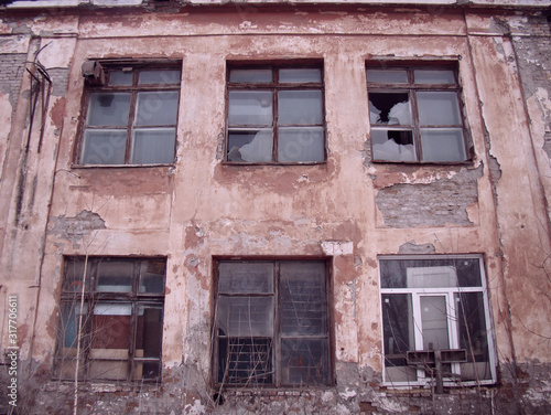 Abandoned house. Broken down windows. Broken glass. Old paint on the brick walls. © Sergei Tim