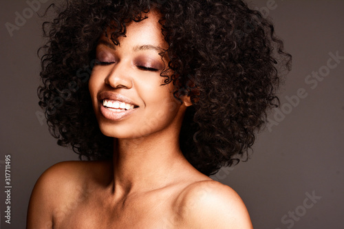 Portrait of a smiling young attractive African American woman with curly hair and clean fresh face
