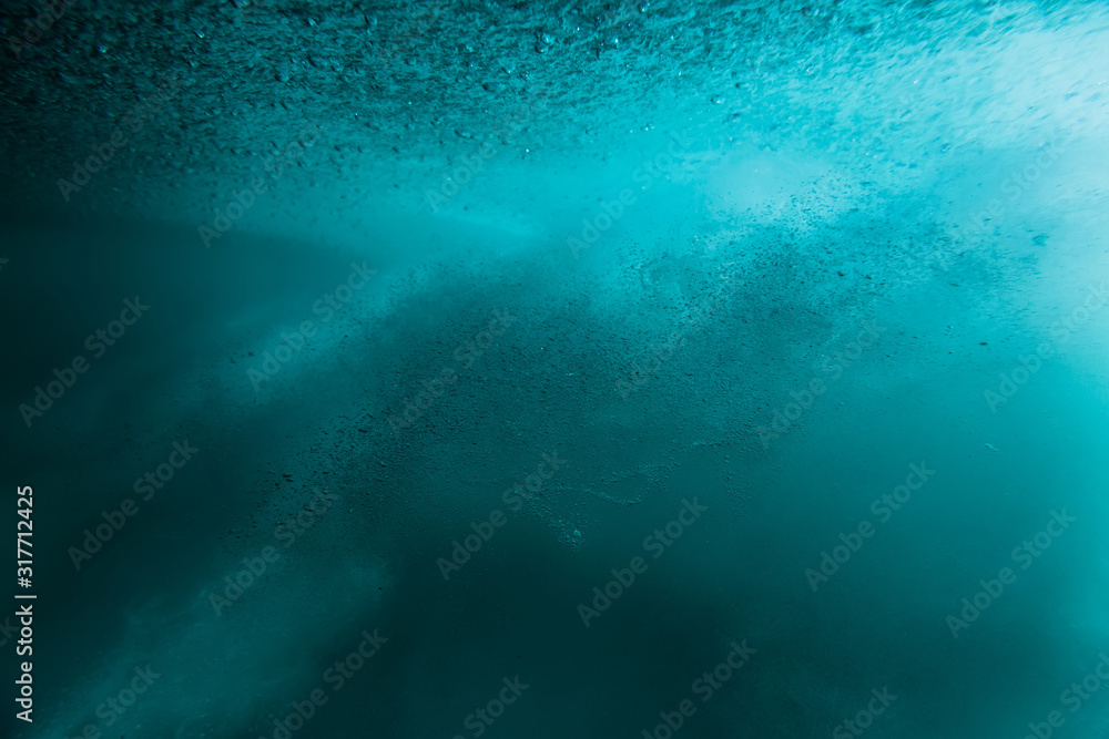 Fototapeta premium Wave with bubbles underwater. Transparent blue ocean in underwater