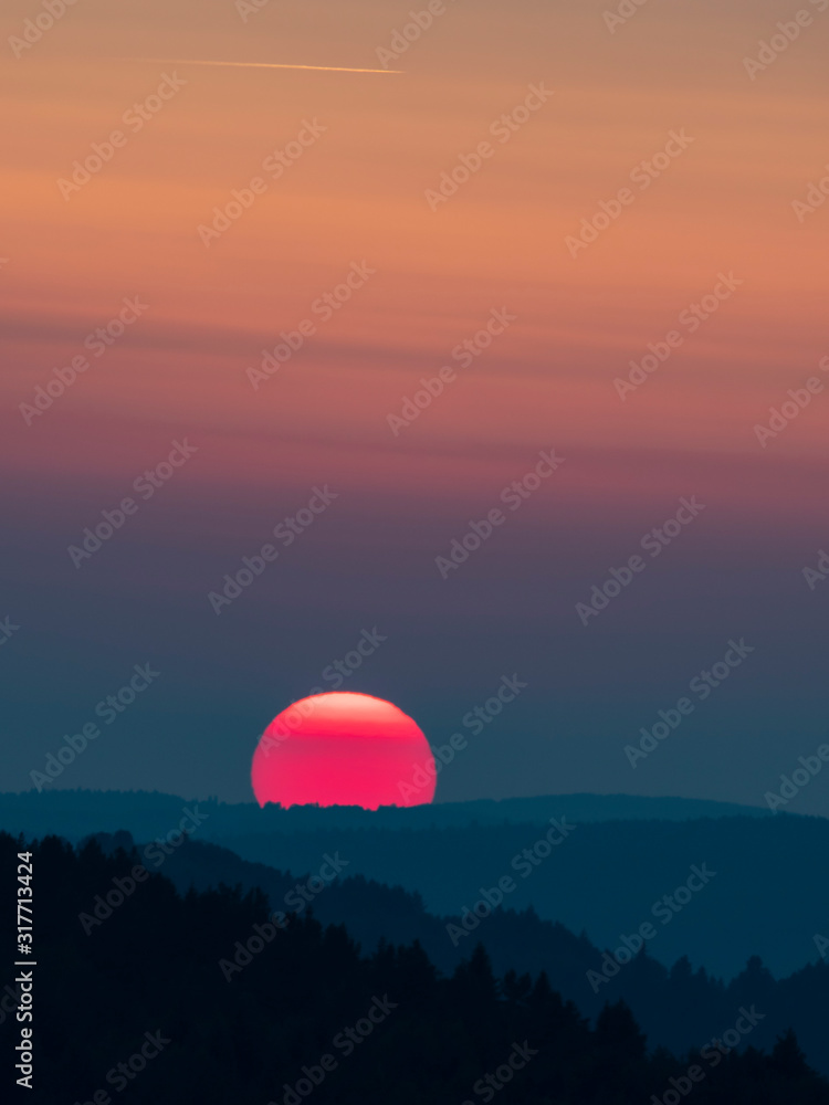 Sunset in the mountains with full disk of sunset under the horizon. Magical sunset in the Carpathians, orange sky, full disk of sunset. Sunset in the mountains with full disk of sunset under the horizon. Magical sunset in the Carpathians, orange sky, full disk of sunset.