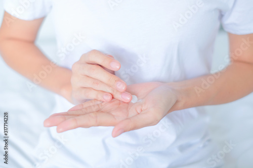 Woman applying moisturizing cream/lotion on hands, beauty concept..