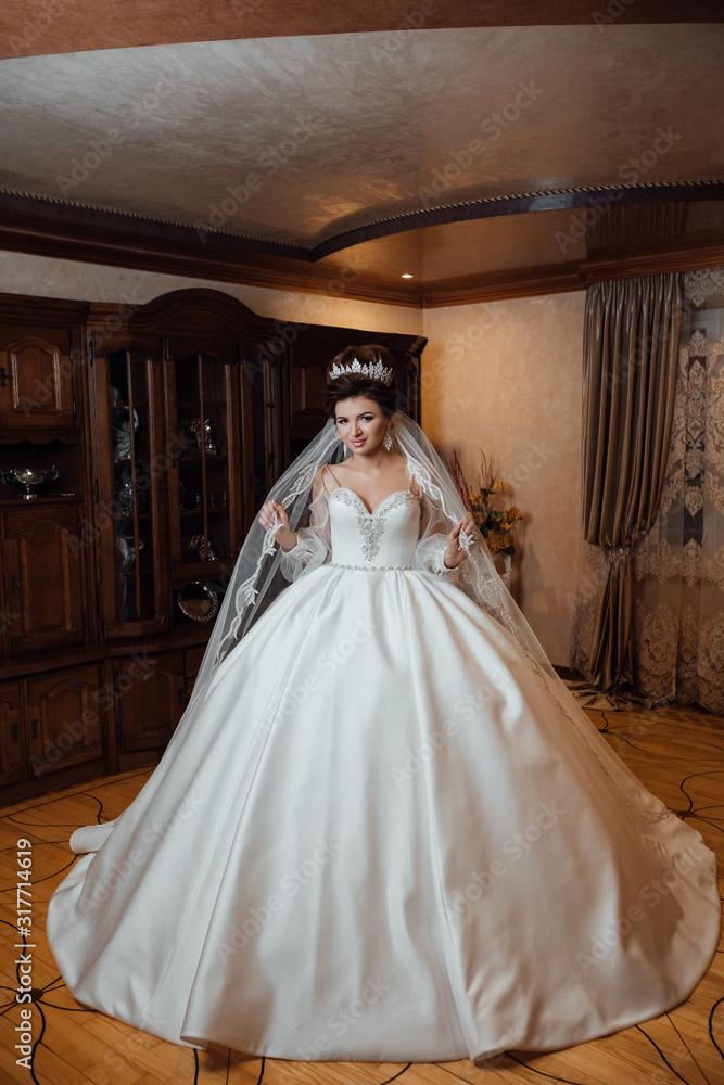 Morning of the bride. Beautiful bride in wedding dress with lace. Interior. Preparing the bride for the upcoming wedding. Wedding accessories. Fashion photo. Young attractive model. Morning of the bride. Beautiful bride in wedding dress with lace. Interior. Preparing the bride for the upcoming wedding. Wedding accessories. Fashion photo. Young attractive model.