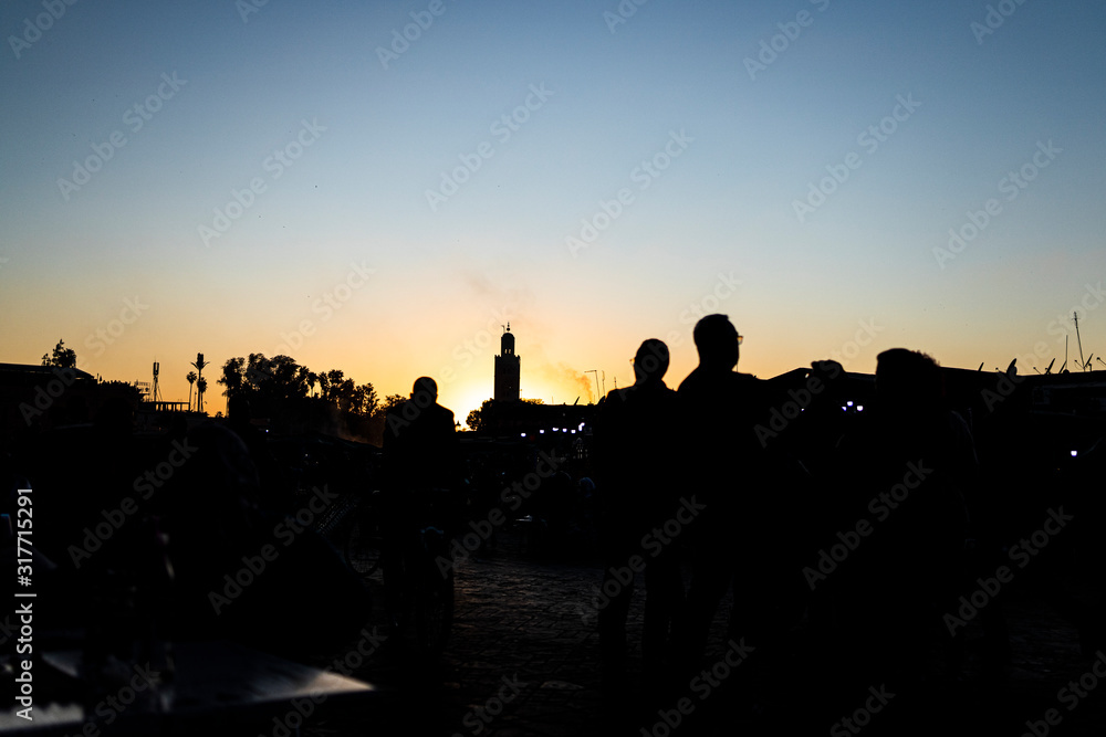 Orange sunset in the tower of the Marrakech square from a square. Morocco..