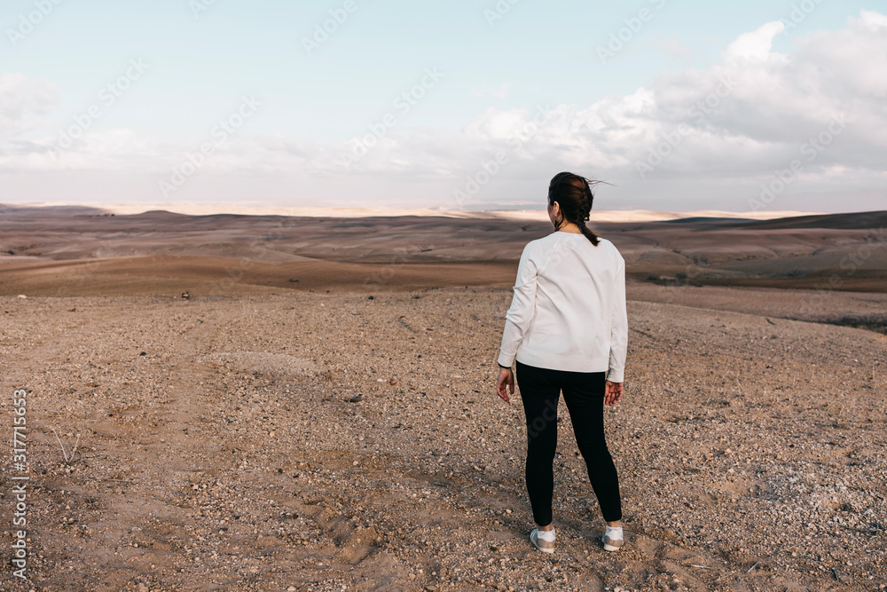 Lonely woman on a rocky desert near of Marrakech Lonely woman on a rocky desert near of Marrakech