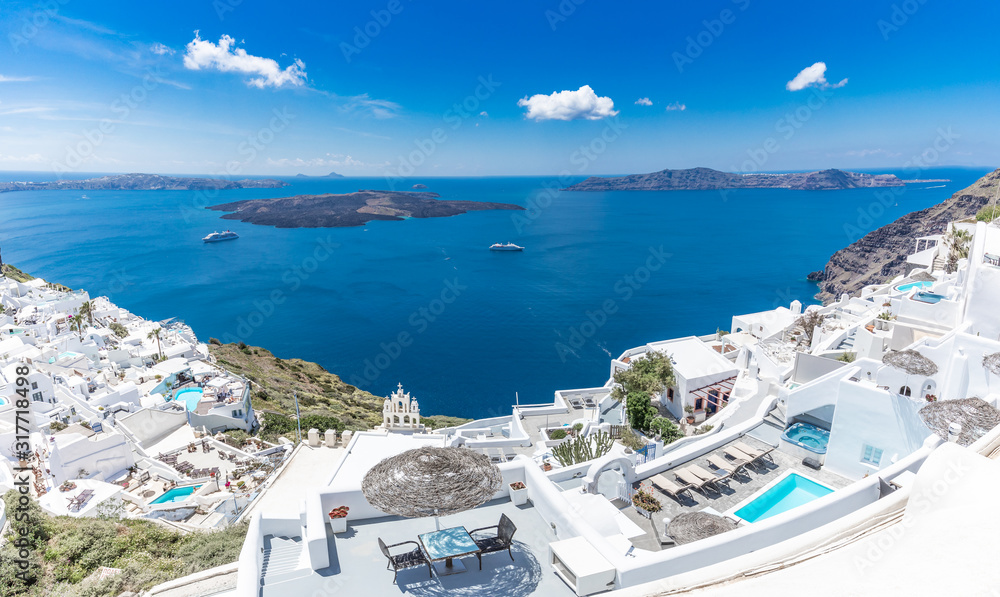  Santorini, Greece. Famous view of traditional white architecture Santorini landscape with flowers in foreground. Summer vacations background. Luxury travel tourism concept. Amazing summer destination