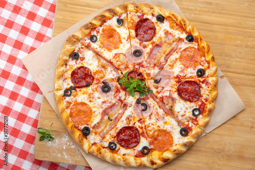 Pizza with different sausages close-up with different ingredients decorated with Basil, an assortment of traditional Italian fast foods