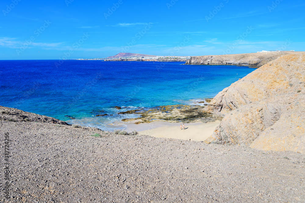 View of beautiful Playa de la Cera beach, from above, blue sea, yellow sand, cliffs. Papagayo, Playa Blanca, Lanzarote, Canary Islands, selective focus