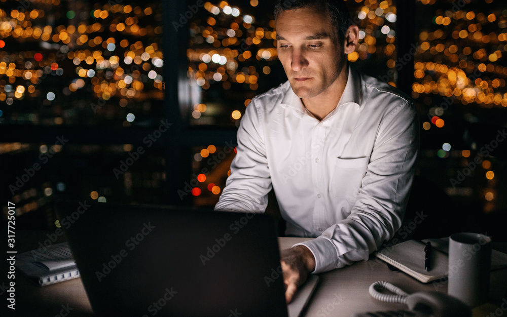 Young businessman working late at night on a laptop Young businessman working late at night on a laptop