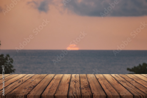 Wooden table for advertising products on the background of the sea sunset 