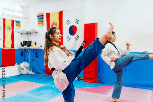 Canvas Print Two young women practice taekwondo in a training center