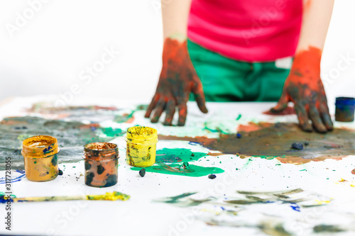 hands in paints on table painted