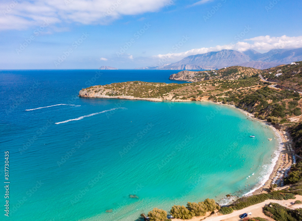 Top view of the Mediterranean coast on the island of Crete, in the frame the beach and beautiful nature. Mountains in the background. Aerial photography