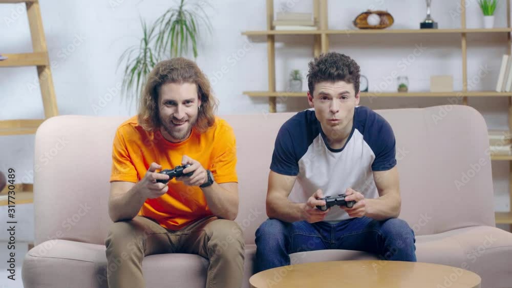 happy man playing video game with upset friend happy man playing video game with upset friend