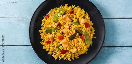 Foto Fried rice with chicken and vegetables in black plate on blue wooden table